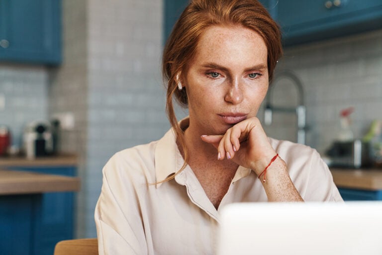 Woman working on a computer with a serious expression